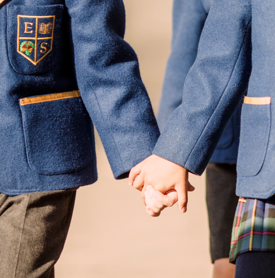 Boy and girl hold hands in Eaton Square school uniform