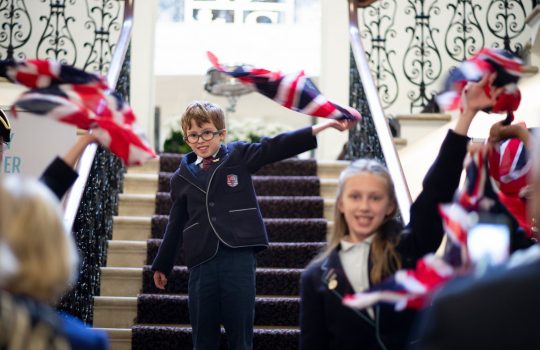 school children waving UK flags